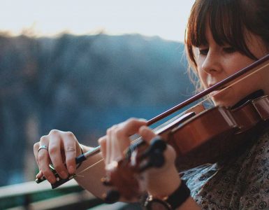 Mujer tocando el violín en el exterior.