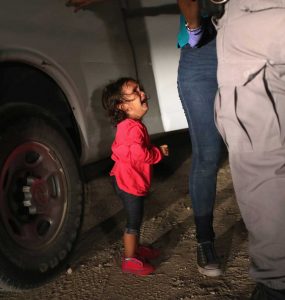 Niña migrante rompe a llorar mientras su madre es detenida por agentes fronterizos.