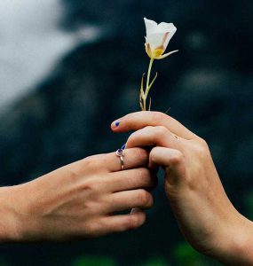 Una persona dando una flor a otra.