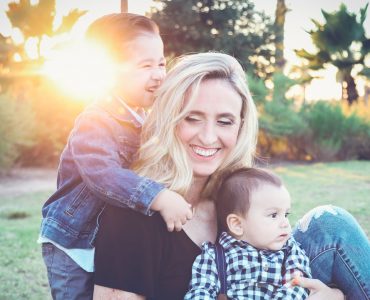 Una madre abraza a sus dos hijos